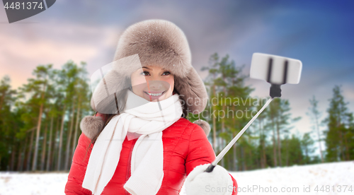 Image of happy woman taking selfie over winter forest