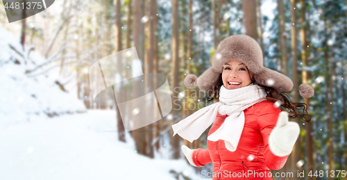 Image of happy woman in fur hat over winter forest