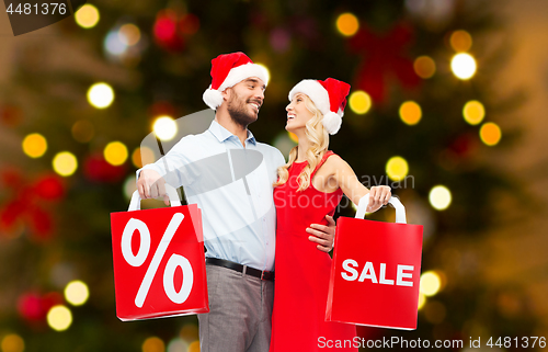 Image of couple in santa hats shopping on christmas