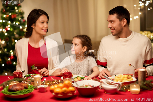 Image of happy family having christmas dinner at home