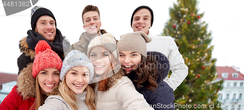 Image of happy friends over christmas tree in old tallinn