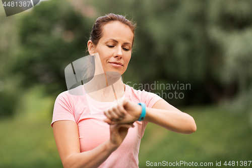 Image of woman with fitness tracker at summer park