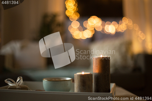 Image of close up of candles, christmas gift and mug