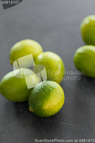 Image of close up of whole limes on slate table top