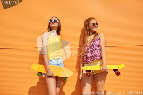 Image of teenage girls with short skateboards in city