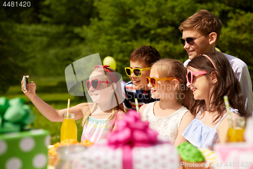 Image of happy kids taking selfie on birthday party