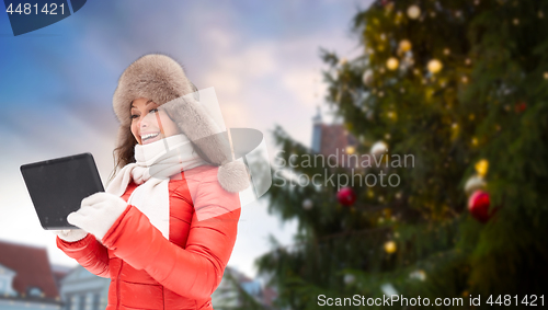 Image of woman with tablet pc over christmas tree