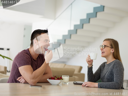 Image of couple enjoying morning coffee and strawberries