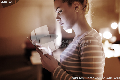 Image of woman working on digital tablet in night office
