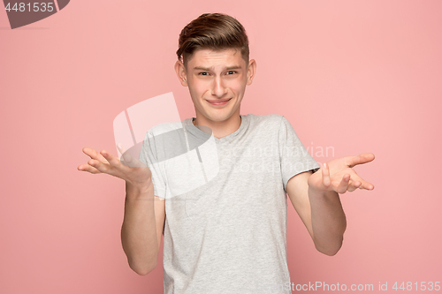 Image of Suspiciont. Doubtful pensive man with thoughtful expression making choice against pink background