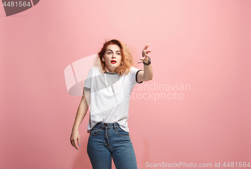 Image of Beautiful female half-length portrait isolated on pink studio backgroud. The young emotional surprised woman