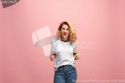 Image of Portrait of an angry woman looking at camera isolated on a pink background