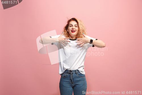 Image of The happy business woman standing and smiling against pink background.