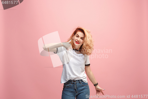 Image of Beautiful female half-length portrait isolated on pink studio backgroud. The young emotional surprised woman