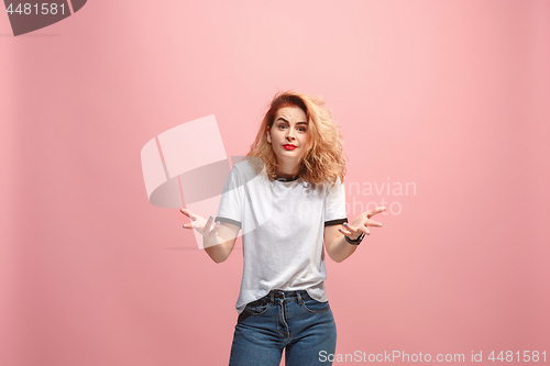 Image of Beautiful female half-length portrait isolated on pink studio backgroud. The young emotional surprised woman