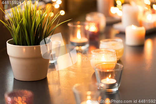 Image of candles burning on window sill with garland lights