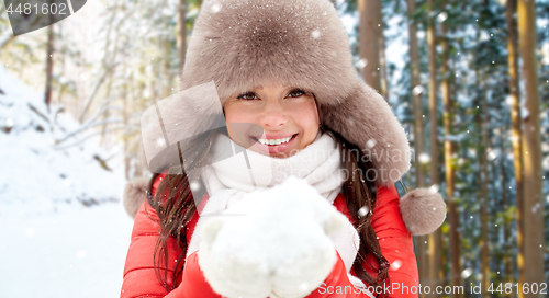 Image of woman in fur hat with snow over winter forest