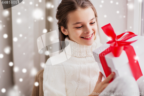 Image of happy beautiful girl with christmas gift at home