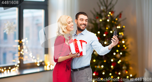 Image of couple taking selfie by smartphone on christmas