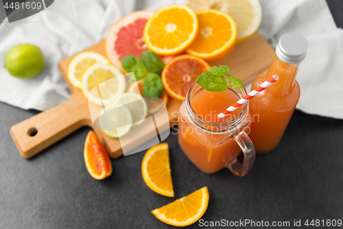 Image of mason jar glass with juice and fruits on table