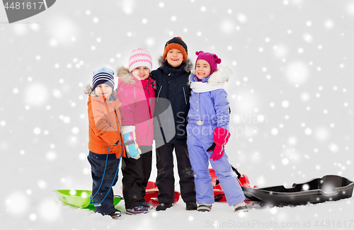 Image of happy little kids with sleds hugging in winter