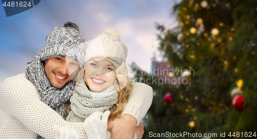 Image of happy couple hugging over christmas tree