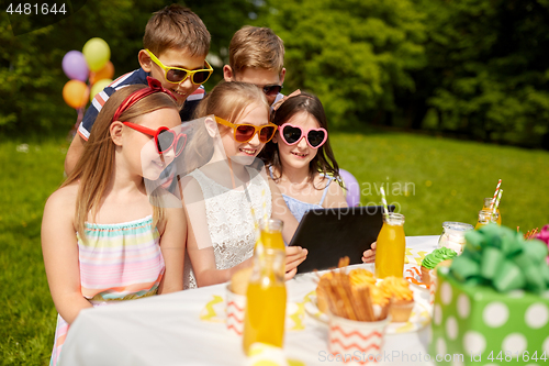 Image of happy kids with tablet pc on birthday party