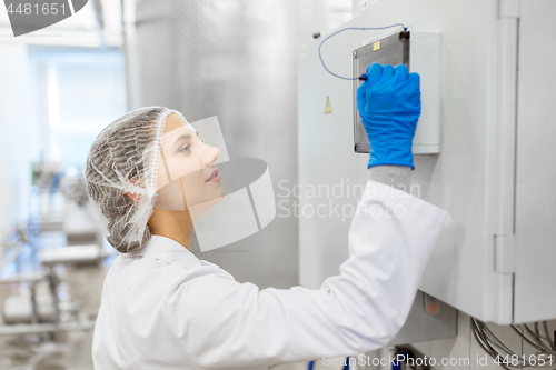 Image of woman programming computer at ice cream factory