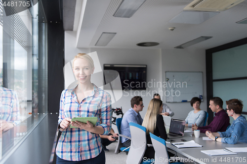 Image of Pretty Businesswoman Using Tablet In Office Building by window