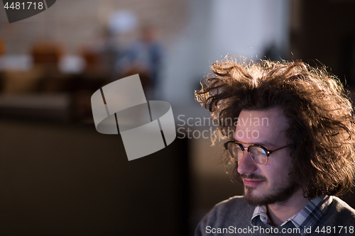 Image of man working on computer in dark office