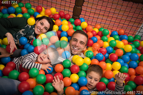 Image of young parents with kids in a children\'s playroom