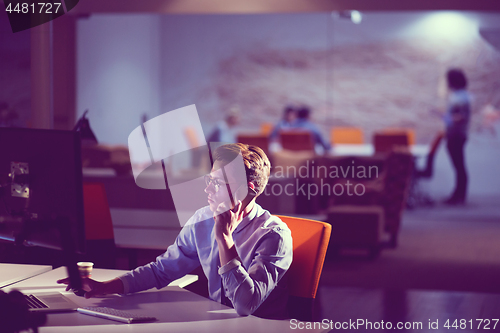 Image of man using mobile phone in dark office