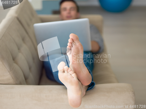 Image of Man using laptop in living room