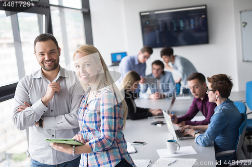 Image of Two Business People Working With Tablet in office