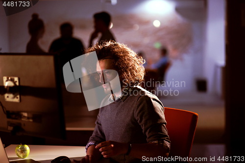 Image of man working on computer in dark office