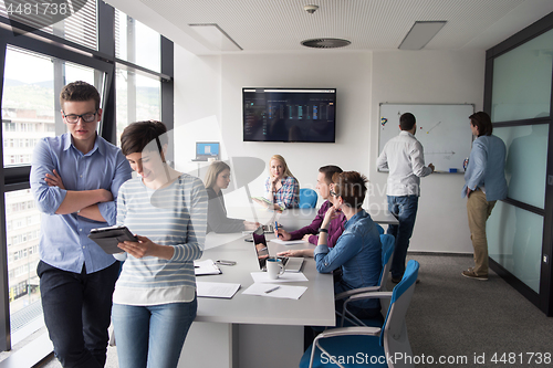 Image of Two Business People Working With Tablet in office