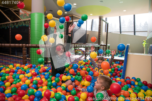 Image of Young mom with her kids in a children\'s playroom