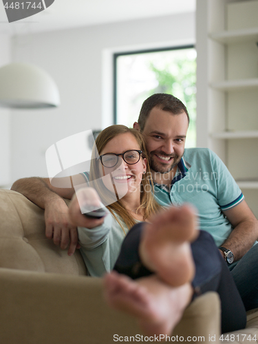 Image of Young couple on the sofa watching television