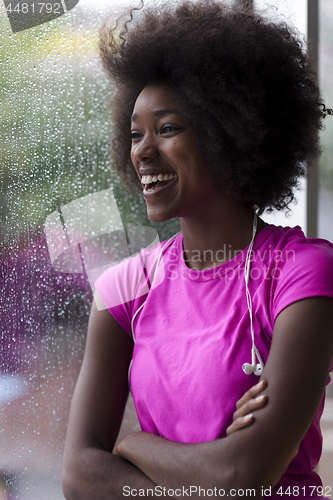 Image of portrait of young afro american woman in gym while listening mus