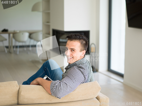 Image of man on sofa using tablet computer