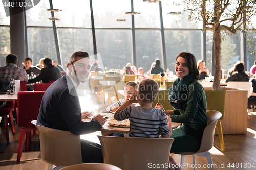 Image of Young parents enjoying lunch time with their children