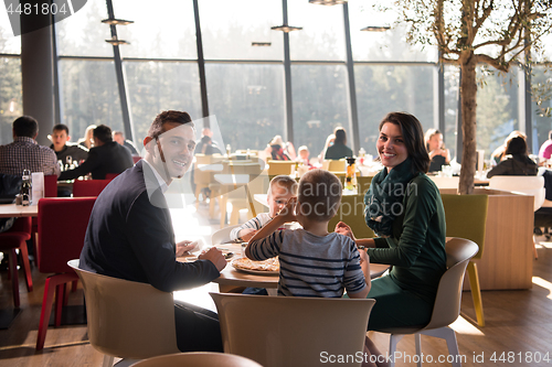 Image of Young parents enjoying lunch time with their children