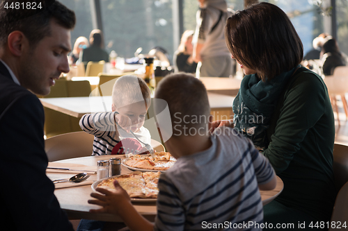 Image of Young parents enjoying lunch time with their children