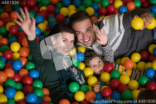 Image of young parents with kids in a children\'s playroom