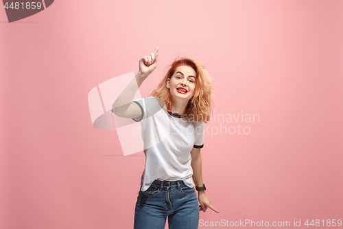 Image of Beautiful female half-length portrait isolated on pink studio backgroud. The young emotional surprised woman