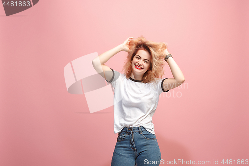 Image of The happy business woman standing and smiling against pink background.