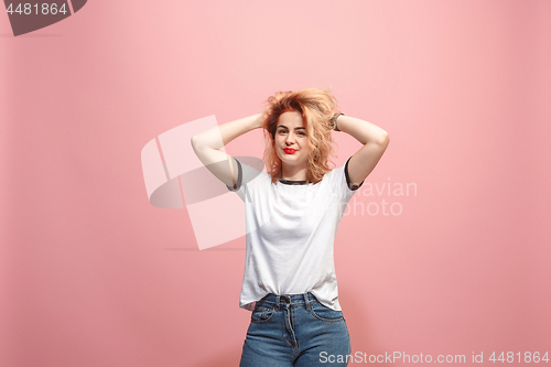 Image of The happy business woman standing and smiling against pink background.