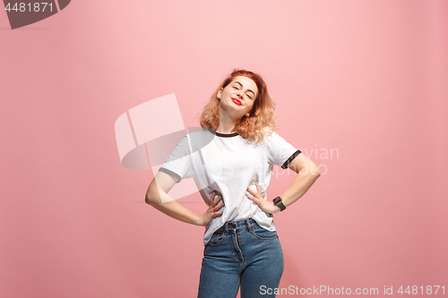 Image of The happy business woman standing and smiling against pink background.