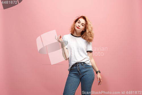 Image of Beautiful female half-length portrait isolated on pink studio backgroud. The young emotional surprised woman