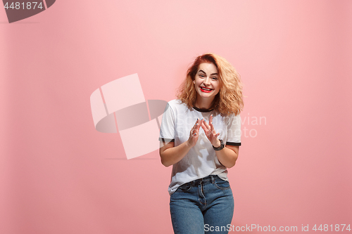 Image of The happy business woman standing and smiling against pink background.